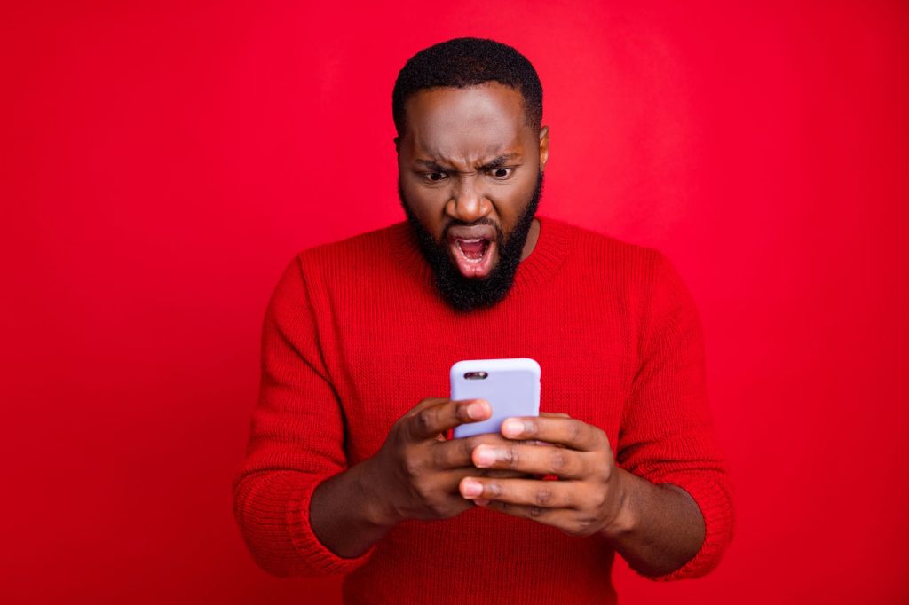 Close-up portrait of his he nice attractive irritated annoyed outraged, bearded guy using wireless connection app 5g blog post smm spam messenger isolated over bright vivid shine red background